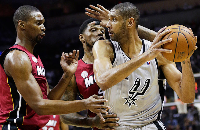 Chris Bosh and Udonis Haslem of the Miami Heat guard Tim Duncan of the San Antonio Spurs